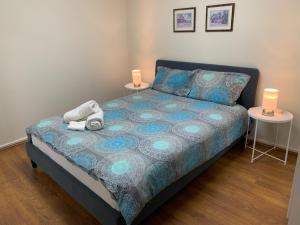 a bedroom with a bed with two tables and two lamps at Chadstone Holiday E2 Villa in Oakleigh
