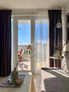 een slaapkamer met een grote glazen deur met uitzicht op de oceaan bij One bedroom appartement at Zaton 200 m away from the beach with furnished garden and wifi in Zaton