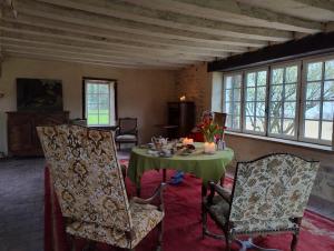 - une salle à manger avec une table et deux chaises dans l'établissement Charnay Mery , une exceptionnelle maison de vacances au calme côté forêt avec piscine, à Vierzon
