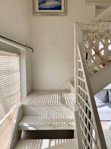 een wit stapelbed in een kamer met een ladder bij One bedroom appartement at Zaton 200 m away from the beach with furnished garden and wifi in Zaton