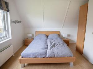 uma cama num quarto com duas mesas de cabeceira e uma janela em Holiday home near Grevelingen Lake em Zonnemaire