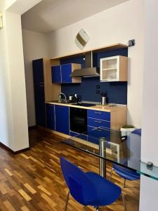 a kitchen with blue cabinets and a glass table and chairs at CasaPratti Pescara centro in Pescara