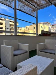 a balcony with chairs and a table and windows at CasaPratti Pescara centro in Pescara