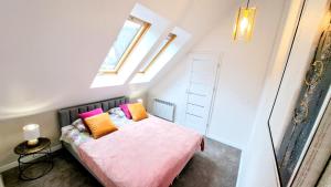 カルパチにある"Apartament Familijny" na osiedlu "Apartamenty pod Śnieżką"のピンクベッド1台、枕2つが備わる小さなベッドルーム1室が備わります。