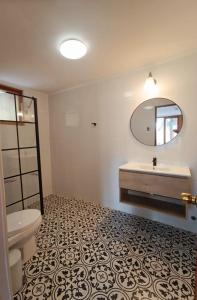 uma casa de banho com um WC, um lavatório e um espelho. em Casa Arrayán em Santiago