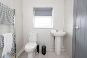 a white bathroom with a toilet and a sink at 25 Station in Ushaw Moor
