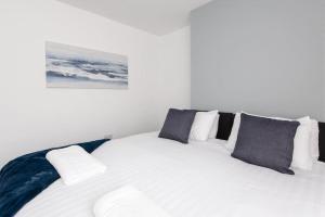 a white bed with black and white pillows on it at 25 Station in Ushaw Moor