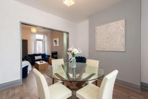 a dining room with a glass table and white chairs at 25 Station in Ushaw Moor