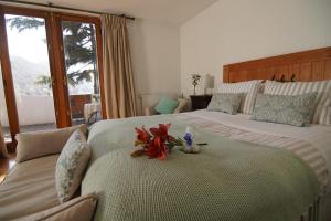 a hotel room with two beds with flowers on the bed at Casa Arrayán in Santiago