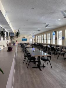 uma cafetaria com mesas e cadeiras num edifício em White Sands Inn, Marina, Bar & Grill em Port Isabel