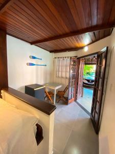 ein Schlafzimmer mit einem Bett und einem Tisch in einem Zimmer in der Unterkunft Solar da Praia Pousada in Arraial do Cabo