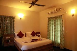 a bedroom with a bed and a ceiling fan at ZIONS HOTEL AND APERTMENT in Devanahalli-Bangalore