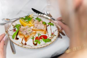 una persona comiendo un plato de comida en una mesa en Pensjonat & Restauracja Admirał, en Jastarnia