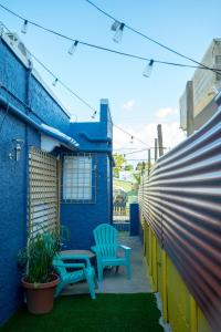 a patio with two chairs and a blue building at Casa Vibe San Juan Great for large groups in San Juan