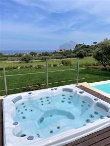 eine Whirlpool-Badewanne auf einer Terrasse in der Unterkunft Villa Maria una finestra sul mare in Valderice