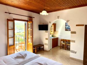 ein Schlafzimmer mit einem Bett und eine Küche mit einem Balkon in der Unterkunft Nicolas Studios in Skala