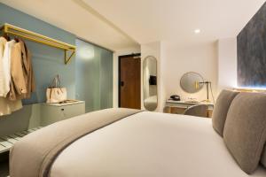 a bedroom with a large white bed and a bathroom at Hotel Indigo London - 1 Leicester Square, an IHG Hotel in London