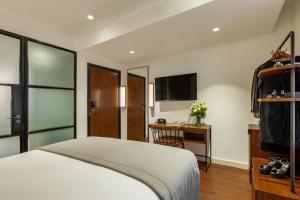 a bedroom with a bed and a desk and a television at Hotel Indigo London - 1 Leicester Square, an IHG Hotel in London