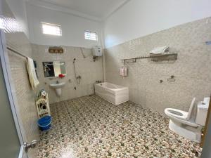 a bathroom with a toilet and a sink and a tub at Tom Homestay in Yên Minh