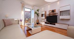 - un salon avec un canapé blanc et une télévision dans l'établissement Palomar Luxury Apartment Split, à Split