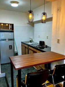 a kitchen with a wooden table and a refrigerator at Departamento en La Paz, en pleno centro histórico in La Paz