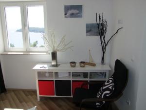 a room with a desk and a chair and two windows at A bright hideaway in Dubrovnik