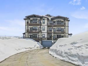a large house in the middle of a snow covered street at Jordanelle Mountain Paradise 204 condo in Heber City