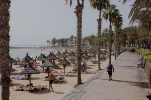 una playa con palmeras y gente en la arena en Adosado en Costa Adeje, en Playa de las Américas