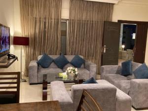 a living room with a couch and blue pillows at Uptown Hotel Apartment in Amman