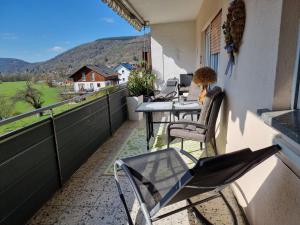 balcón con mesas y sillas y vistas a una granja en Ferienwohnung Mohnblume 