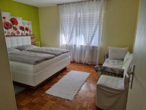 ein kleines Schlafzimmer mit einem Bett und einem Fenster in der Unterkunft Ferienwohnung Mohnblume 