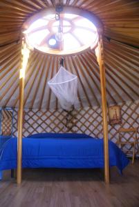 Habitación con cama azul en una yurta en Yurta Flora, en Torino di Sangro