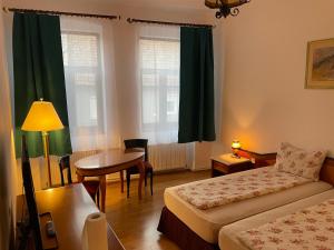 um quarto de hotel com uma cama, uma mesa e uma secretária em Pensiunea Mimi em Mediaş
