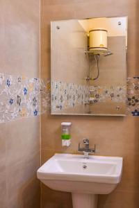 a bathroom with a sink and a mirror at Hotel Sarai Bharatgarh in Chandīgarh