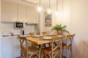 una cocina con una mesa de madera con sillas alrededor. en CityLiving, en Oporto