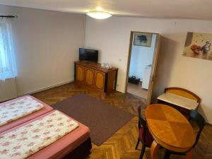 a room with two beds and a table and a television at Pensiunea Mimi in Mediaş