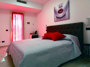 Schlafzimmer mit einem großen Bett und einem roten Kissen in der Unterkunft B&B La casa di Graz in Reggio nell'Emilia