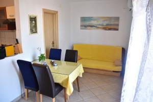 a dining room with a yellow table and chairs at One bedroom appartement at Slatine 250 m away from the beach with sea view enclosed garden and wifi in Slatine