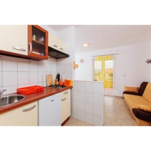 a kitchen with a sink and a couch in a room at One bedroom appartement at Slatine 250 m away from the beach with sea view enclosed garden and wifi in Slatine