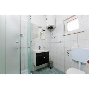 a bathroom with a glass shower and a sink at One bedroom appartement at Slatine 250 m away from the beach with sea view enclosed garden and wifi in Slatine