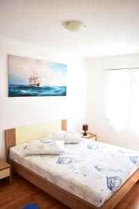 a bedroom with a bed with a painting on the wall at One bedroom appartement at Slatine 250 m away from the beach with sea view enclosed garden and wifi in Slatine