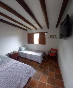 ビージャ・デ・レイバにあるHostal Villa Dulceyのベッドルーム1室(ベッド2台、薄型テレビ付)