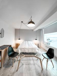 um quarto com uma cama e duas cadeiras pretas em Hotel Patagonia Signature em San Carlos de Bariloche