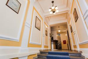 een hal met een trap in een gebouw met een kroonluchter bij Sibelius Apartments in Praag