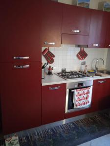 a kitchen with red cabinets and a stove at Zena in Genoa
