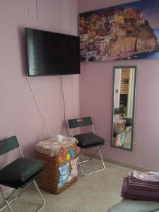 熱那亞的住宿－Zena，一间房间,配有两把椅子和墙上的电视