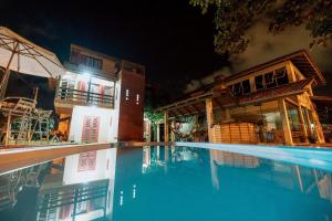 ein Schwimmbad vor einem Haus in der Nacht in der Unterkunft Pousada Casa Aratuca - 200mt da praia in São Francisco do Sul