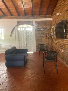 - un salon avec un canapé bleu et deux chaises dans l'établissement PARCELA VILLA PAU, à Lebrija