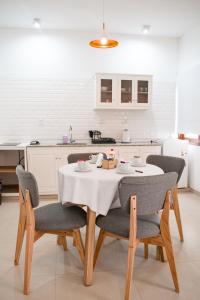 uma cozinha com uma mesa com cadeiras e uma toalha de mesa branca em SOMMER Y SOL em Cafayate