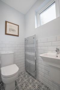 Baño blanco con aseo y lavamanos en Castle Lane House, en Enniskillen